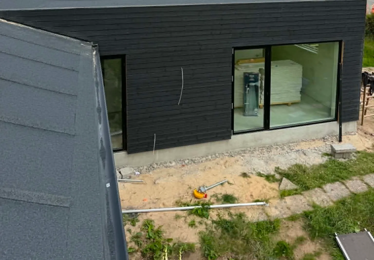 Sort moderne tilbygning med fladt tag bygget af Brix Byg