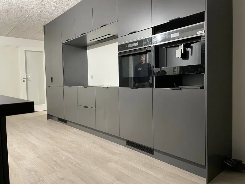 Moderne gråt køkken med indbyggede hvidevarer monteret af Brix Byg i Midtjylland